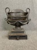 A Regency style cast iron and steel fire basket of vase shape on pedestal base fitted with a