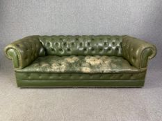 A Chesterfield sofa in deep buttoned leather upholstery. (Distressed and worn as seen). H.75 W.221