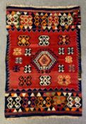A kelim carpet with stylised motifs across the burgundy field. L.232 W.151cm