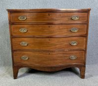 A Georgian mahogany and satinwood strung serpentine fronted chest of four long drawers raised on
