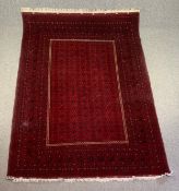 A Heriz carpet with stylised foliate decoration across the burgundy field within wide geometric