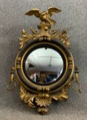 A Regency carved giltwood convex girandole mirror with eagle surmount and scrolling foliate