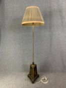 An Egyptian revival brass and painted wood standard lamp with ebonised and gilt winged lion