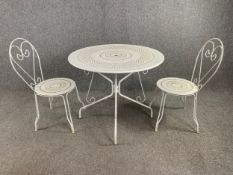 A 19th central style metal conservatory or garden table and a matching pair of chairs. Dia.90cm (