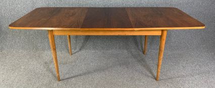 A mid century teak extending dining table with extra leaf. H.72 W.145 (196 extended) D.87cm
