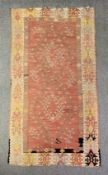 A kelim carpet with hooked flowerhead medallions within a stylised foliate border. L.268 W.138cm