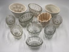 A collection of eleven 19th century and later ceramic and glass jelly moulds. H.10cm (largest).