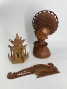 A carved Balinese bust and a similar hair brush along with a stone carved temple. H.30cm (largest)