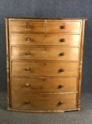A 19th century tall bow fronted pine chest of two short above five drawers flanked by turned