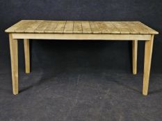 A 20th century weathered teak garden or conservatory table, with a slatted top. H.75 W.160 D.80cm.