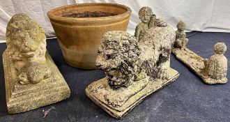 A collection of weathered composite stone garden figures along with a terracotta planter. Largest