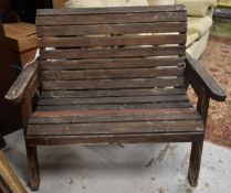A weathered teak garden bench. H.100 W.115 D.75cm