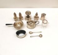 A collection of silver including a set of salt and pepper shakers, a silver tea strainer, two