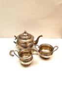 A 1960's London assay office three piece silver tea set with scrolling design to the edges.