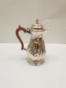 A George III repousse silver Rococo style coffee pot with wooden handle. Hallmarked:T.W, 1769,