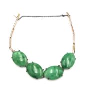 A yellow metal spring link and jade cabochon bracelet. Fastens with a hidden push clasp with