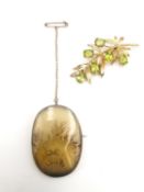 Two early 20th century 9ct gold brooches, one in the form of a branch with peridots for berries,