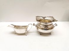 An Art Deco Viners Ltd silver gravy boat and a Greek floral form sugar bowl with bow and ribbon