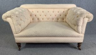 A late 19th century deep buttoned small sofa on turned walnut supports. H.78 W.153 D.82cm