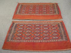 A pair of large Turkomen cushion or pillow covers with repeating hooked lozenge motifs on a burgundy
