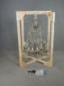 A vintage metal framed twelve branch chandelier with cut crystal swags and drops. H.135cm.