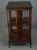 Revolving bookcase, Edwardian mahogany on squat cabriole supports. H.89 W.49 D.49cm.