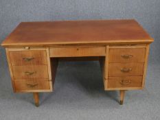 A mid century teak pedestal desk with fitted stationery drawer. H.78 W.137 D.76cm.