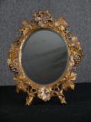 A giltwood dressing table mirror carved with leaves and berries. H.42 W.32cm.