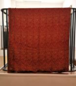 A red silk textile wall hanging with embroidered Arabic text, possibly verses from the Quran. H.