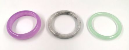 Three Jade bangles in lavender, grey and light green jade, Dia.8cm (largest).