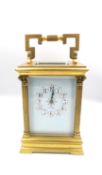 A brass carriage clock, C.1900 marked Dundee to the enamel face with Arabic numerals flanked by
