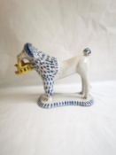 A hand decorated Spanish ceramic dog holding a basket with a bird inside, signed to base. H.19 L.