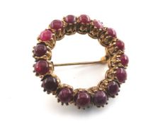 A 9ct gold brooch set with sixteen cabochon rubies. Dia.3cm.