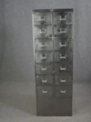 A mid century metal stationery cabinet fitted with a bank of fourteen drawers. H.152 W.52 D.54cm.