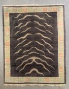 A Nepalese hand woven wool carpet with tiger stripe motif within a geometric border. L.255 W.198cm