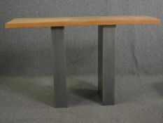 A Conran contemporary console table on metal clad pedestal supports. H.85 W.140 D.44cm.