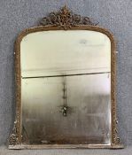 A large 19th century giltwood and gesso overmantel mirror with scrolling foliate cresting above