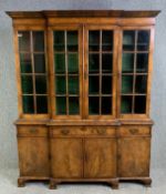 An early 20th century walnut and crossbanded breakfront bookcase in the Georgian style in two