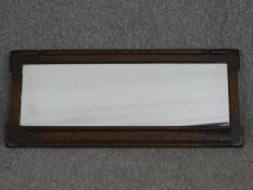 A mid century Ercol oak framed mirror. H.33 W.76cm.
