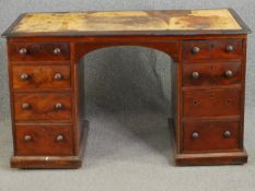 A mid 19th century mahogany pedestal desk with an inset leather top above an arrangement of