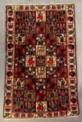 A hand woven Bakhtiar carpet with repeating panels within a stylised border. L.241 W.151cm