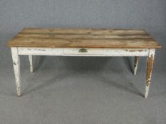 A 19th century distressed painted farmhouse table with pine planked top fitted with frieze drawer on