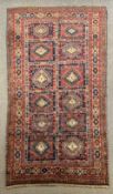 A Karabah carpet with repeating lozenge motifs in panels within stylised flowerhead multiple