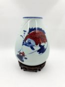 A Chinese vase, hand decorated Koi carp design on a hardwood stand. Character marks to base. H.