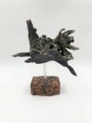 A ceramic figure of a horse in flight raised on a stone base. H.24 W.27cm