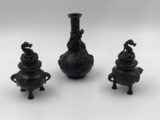 A pair of Chinese bronze lidded censers with dragon decoration and a similar vase. H.16cm (largest).