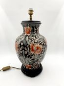 A Chinese style table lamp in the form of a baluster vase on a carved hardwood base. H.44cm