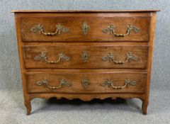 A late 19th century French provincial chestnut chest of drawers, serpentine fronted on squat