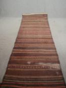 A kelim runner with stylised geometric bands. L.338 W.112cm.