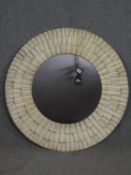 A contemporary wall mirror framed in bands of corrugated metal. Dia.105cm.